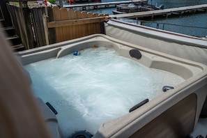 A hot tub with a wooden fence in the background.