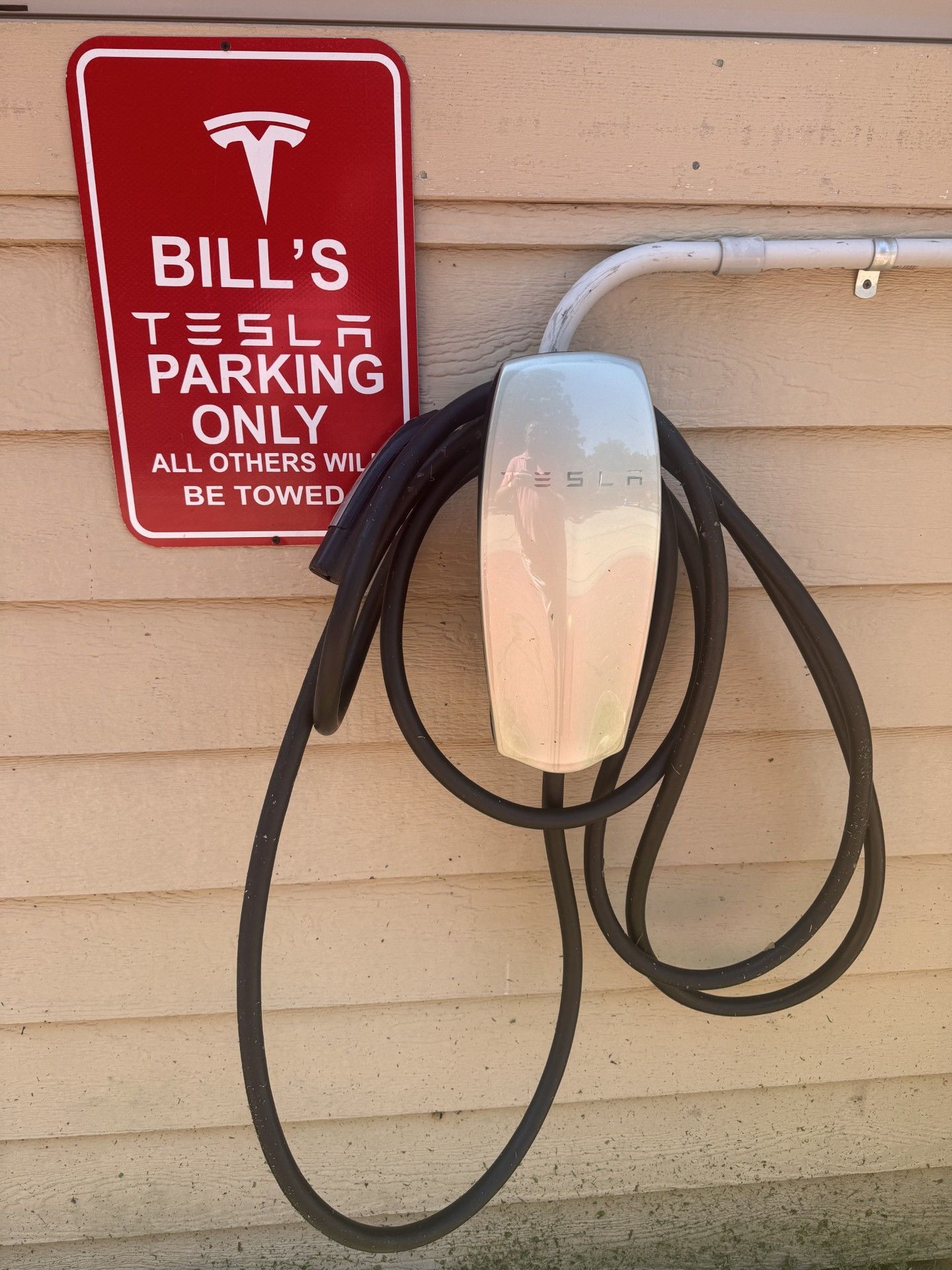 Uma estação de carregamento da Tesla com uma placa indicando que é só para estacionamento do Bill.