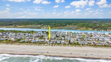 A coastal residential area with houses, a beach, and a river.