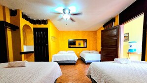 A hotel room with two beds, a ceiling fan, a wall-mounted TV, and a water dispenser. - Don Valentino (Antigua Guatemala)