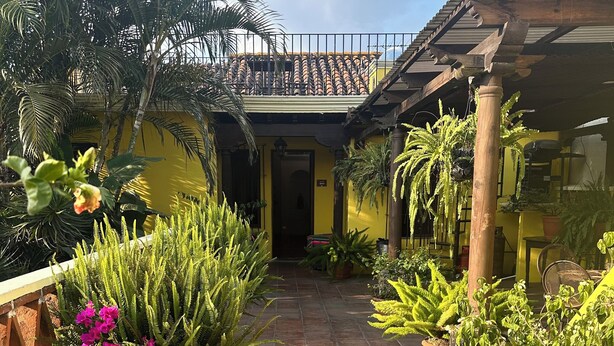A courtyard with potted plants and a tiled floor. - Don Valentino (Antigua Guatemala)