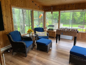 Relax in a serene space with a garden view, comfortable wicker furniture, and a foosball table.