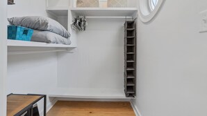 Ein Zimmer mit Einbauschrank, einem kleinen Tisch und einem Fenster.
