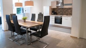 A modern kitchen with white cabinets, a stainless steel range hood, and a built-in oven. - 'Villa Nordhang - Apartment 4' with Mountain View, Balcony & Wi-Fi (Winterberg)