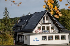 Ein Gebäude mit Solaranlage, Balkon und der Aufschrift 'Villa Nordhang'.