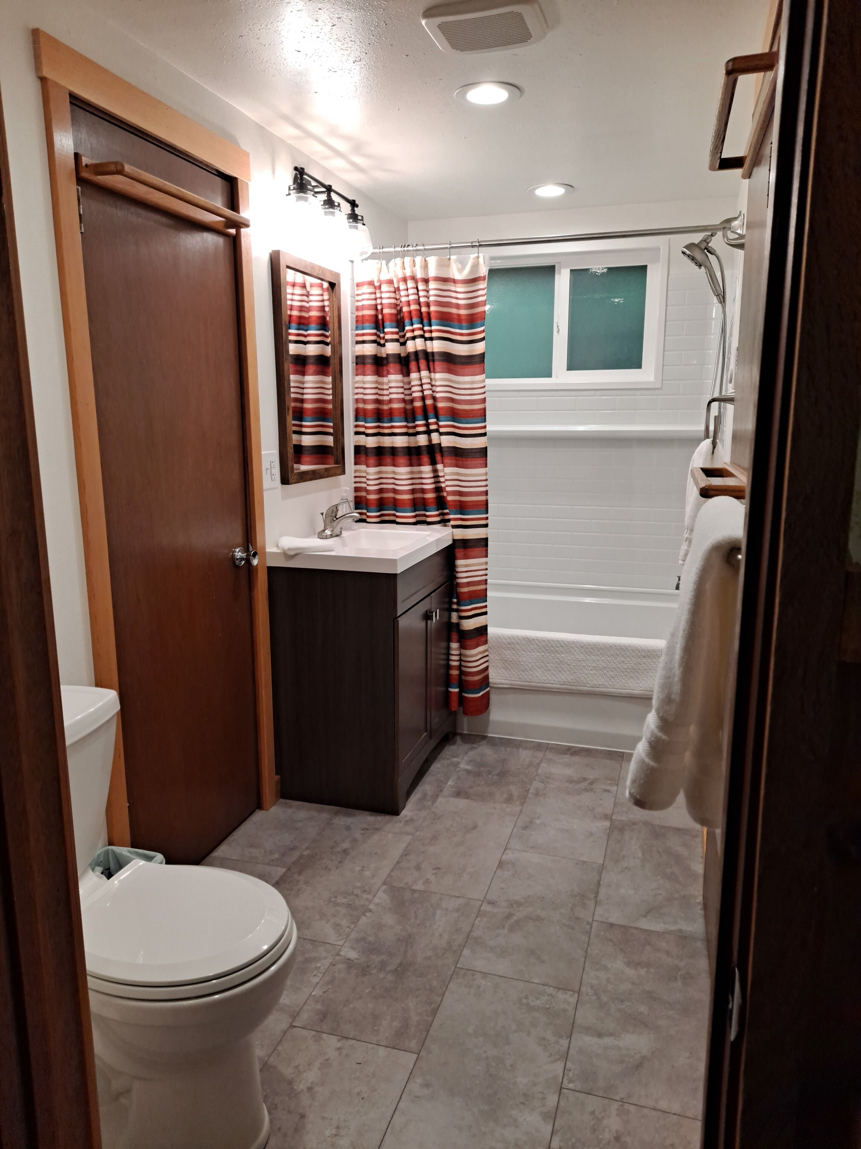 Ein Badezimmer mit Toilette, Waschbecken, Spiegel und Dusche.