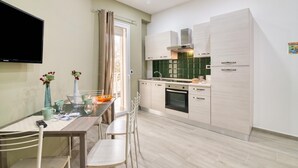 A modern kitchen with a dining area, a flat-screen TV, and a window with curtains. - Eclisse House Few Steps From The Sea, Augusta, Italy (Augusta)