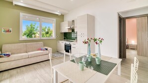 Un appartement moderne comprenant un coin repas, une kitchenette et un canapé.