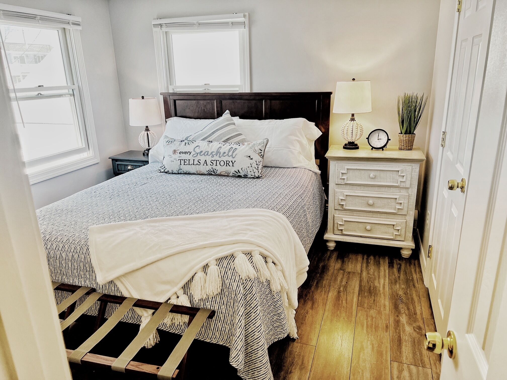 Un dormitorio con cama, mesitas de noche, cómoda y ventana.