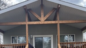 A two-story house with a covered porch and a staircase leading to the entrance. - 🇨🇦 Lake Winnipeg Fishing All-Seasonal Retreat (Winnipeg Beach)