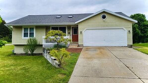 A single-story house with a front porch, a garage, and a well-maintained lawn.