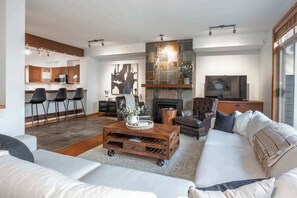 Uma sala de estar moderna com sofá, mesa de centro, lareira e televisão.