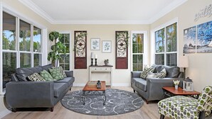 A living room with two grey sofas, a coffee table, and a patterned rug.
