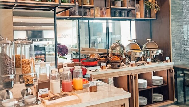 A breakfast buffet area with various food items, glassware, and condiments. - FOX Lite Hotel Grogol Jakarta (Jakarta)