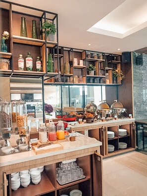 A breakfast buffet area with various food items, glassware, and condiments. - FOX Lite Hotel Grogol Jakarta (Jakarta)