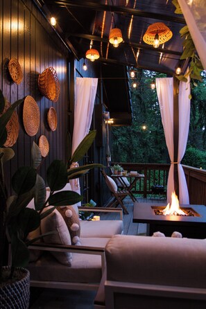A cozy outdoor patio with wicker baskets, a fire pit, and comfortable seating.
