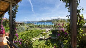 Ein Garten mit Blick auf ein Gewässer und Berge.