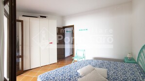 Ein Schlafzimmer mit Bett, Kleiderschrank, Stuhl und Nachttisch.