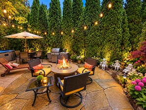 Une terrasse extérieure avec un foyer, des sièges et un barbecue.