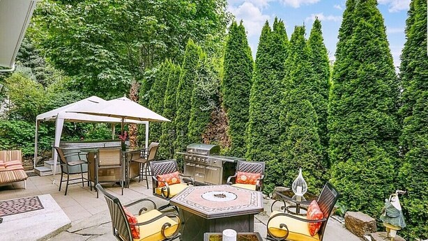 An outdoor patio with a grill, seating area, and a decorative fire pit. - Charming & Cozy Apartment w/ Hot tub patio. (Kenmore)
