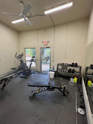 A gym with exercise equipment, a ceiling fan, and an exit sign. - Lakeshore Villas Resort - Three Bedroom Lakefront Condo  (Osoyoos)