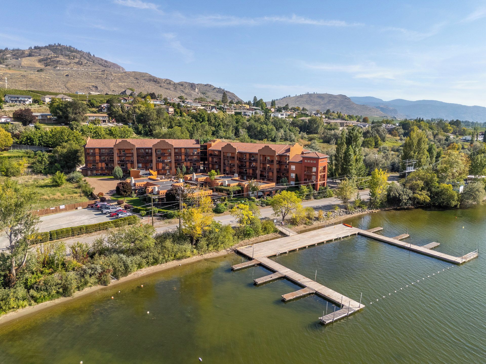 Un hôtel comprenant plusieurs bâtiments, un quai et un lac.