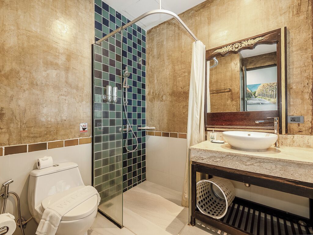 Un baño con ducha de vidrio, lavamanos blanco y un espejo grande.