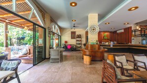 A spacious lobby with a reception desk, seating area, and a large wall clock. - Coco Paradiso Phuket Hotel (Chalong)