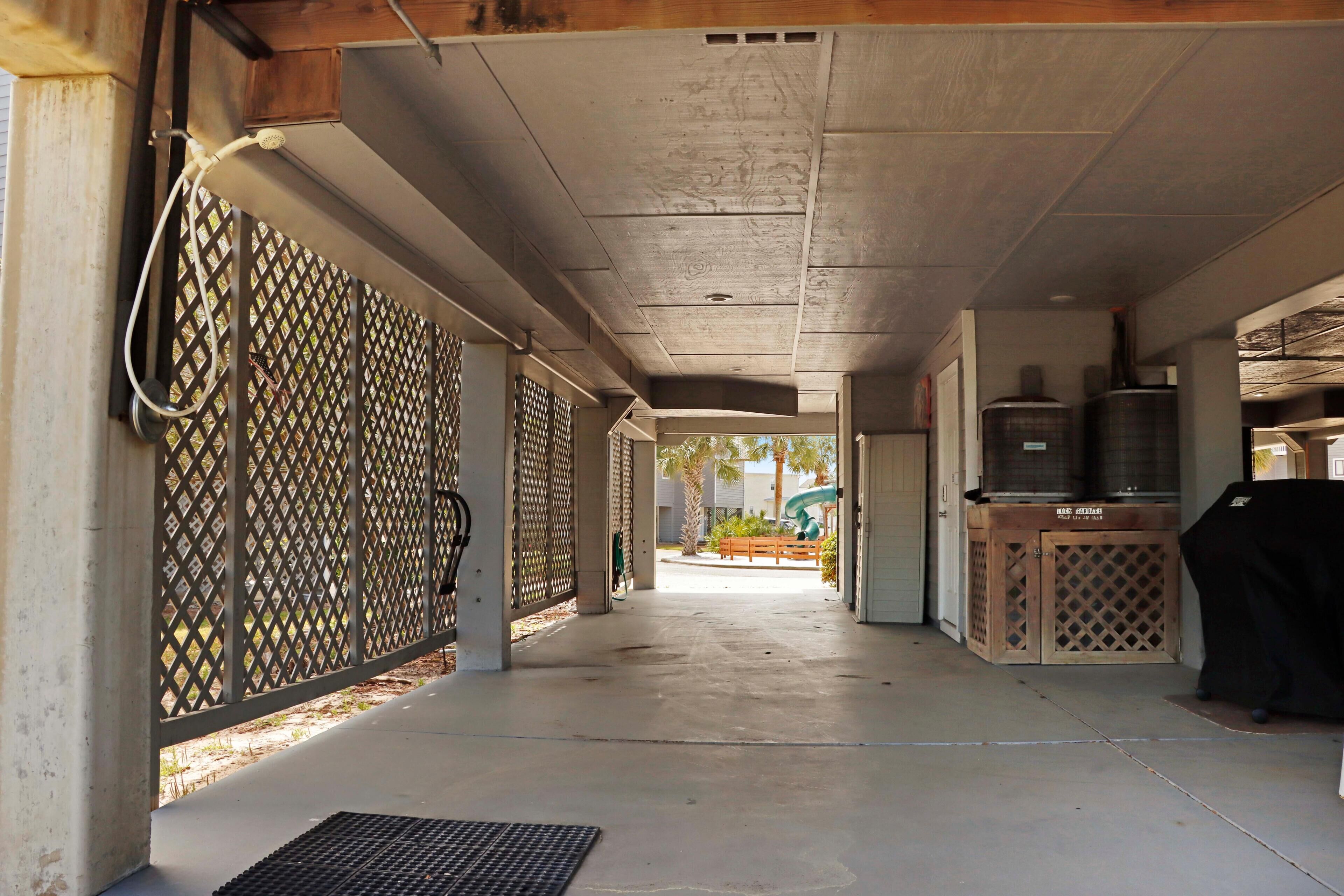 A covered outdoor area with a concrete floor, a grill, and a water heater.