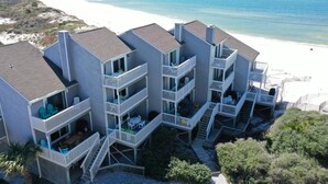 A beachfront hotel with multiple balconies, outdoor seating, and a view of the beach. - Barrier Dunes 161 - 195 (Port St. Joe)