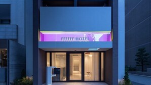 En hotelindgang med et moderne design, med et tydeligt skilt der siger "FFFFFF HOTEL".