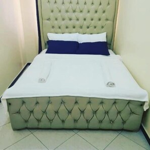 Rest on a comfortable single bed with a tufted headboard.