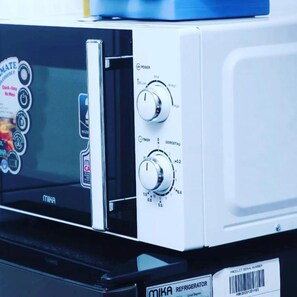 Features a refrigerator with a front control panel and glass door.
