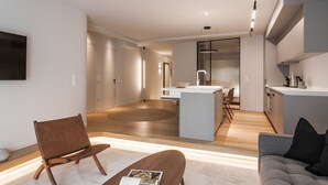 A modern living room with a sofa, a coffee table, and a TV mounted on the wall. - Marvelous 2BR Apartment with balcony  B (Athens)