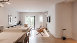 A modern kitchen with a large island, a dining area with a wooden chair, and a large window with curtains. - Marvelous 2BR Apartment with balcony  B (Athens)