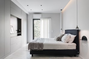 A modern bedroom with a bed, a wardrobe, and a balcony with a view.