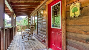 A wooden cabin with a red door, a porch with rocking chairs, and a welcome sign. - Little Slice of Heaven -1BR 1BA Close to Town and Resort Amenities (Sevierville)