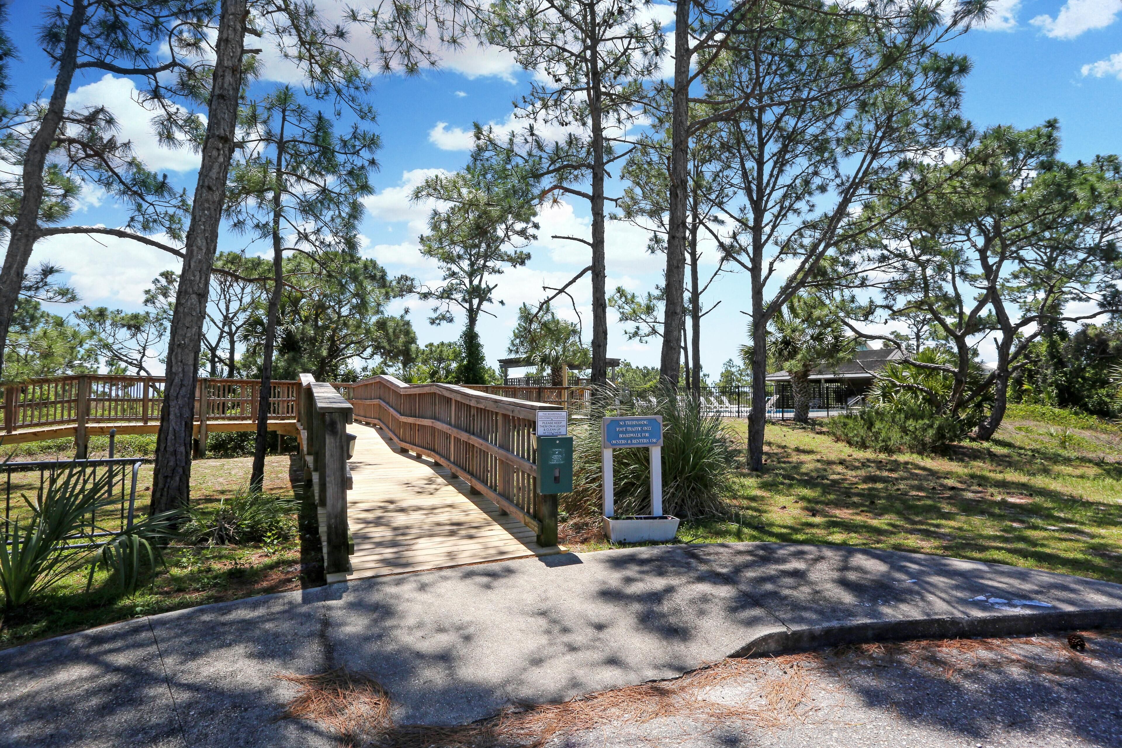 A wooden bridge leading to a building with a sign indicating a park entrance.
