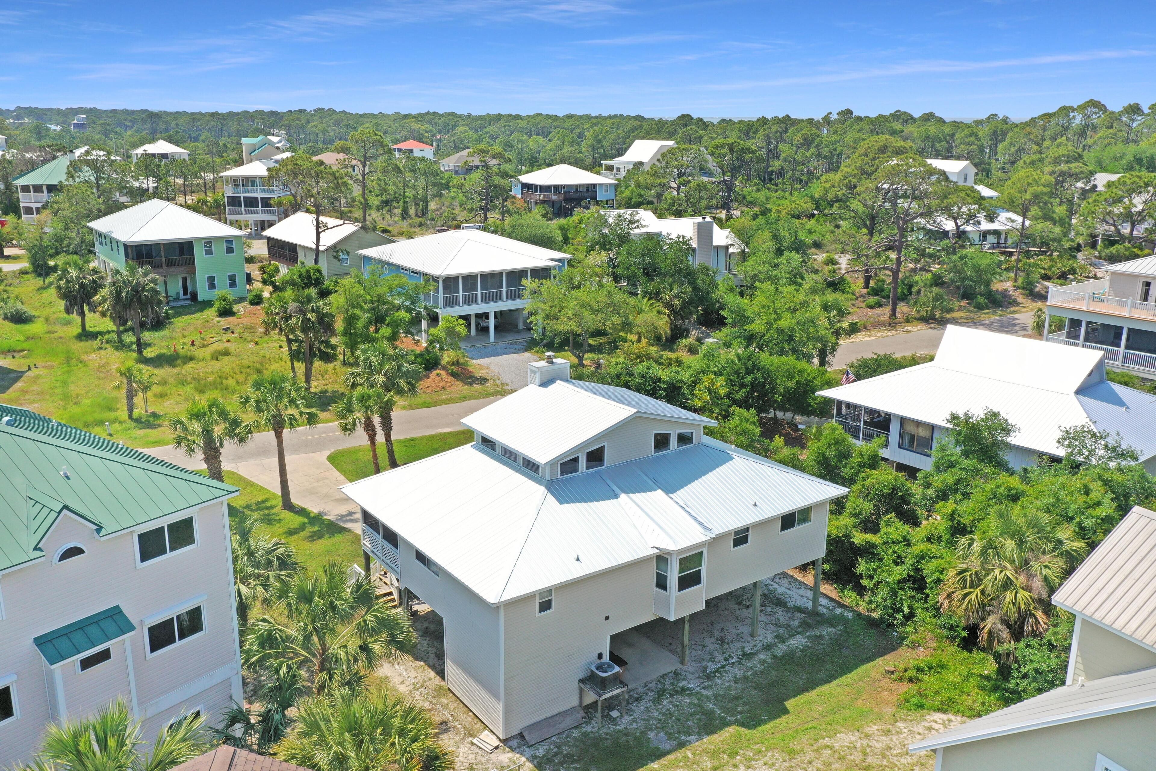 A residential area with multiple two-story houses, each featuring a flat roof and surrounded by greenery.