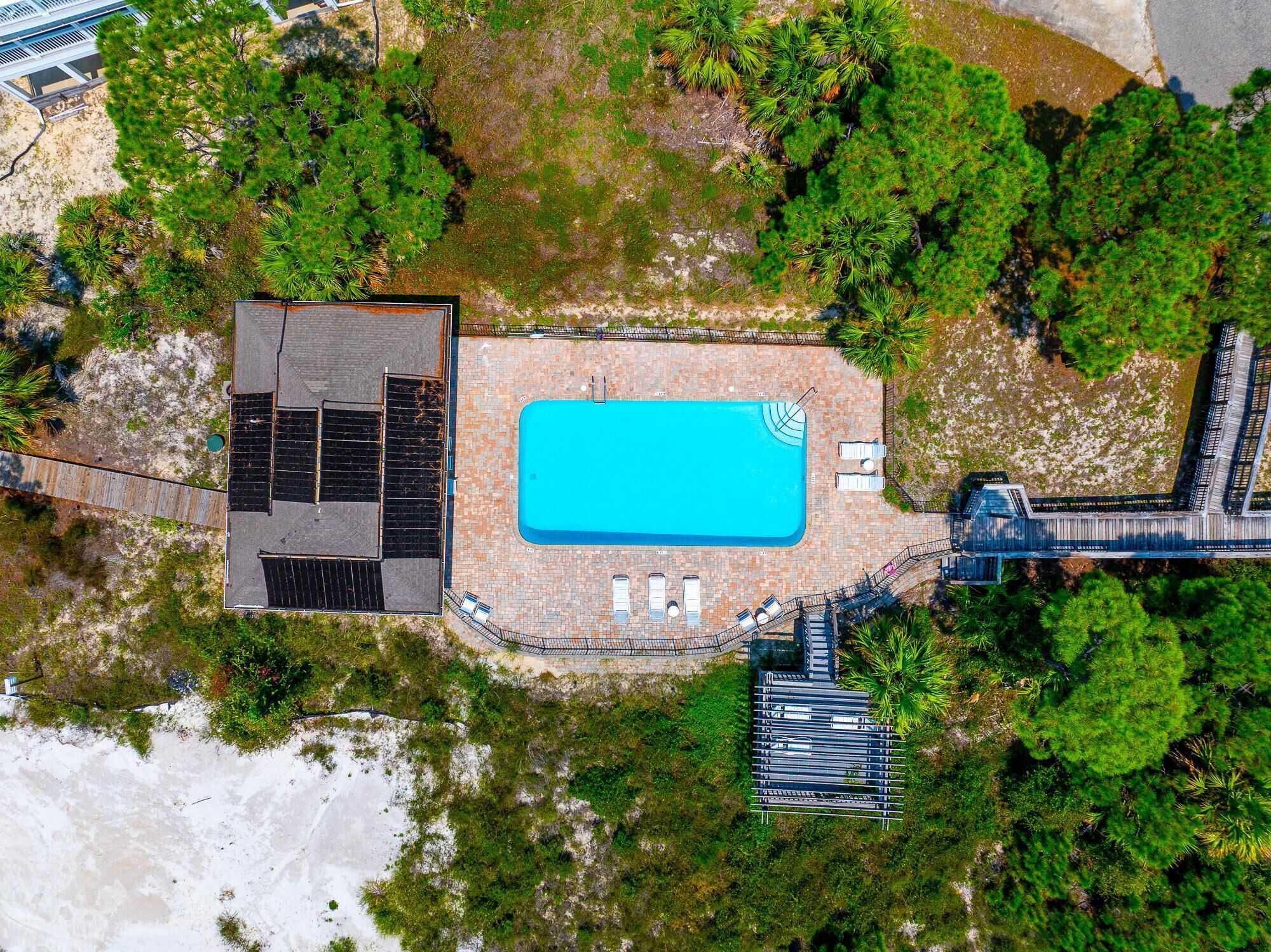 Vista aérea de una propiedad con piscina, terraza cubierta y estacionamiento.
