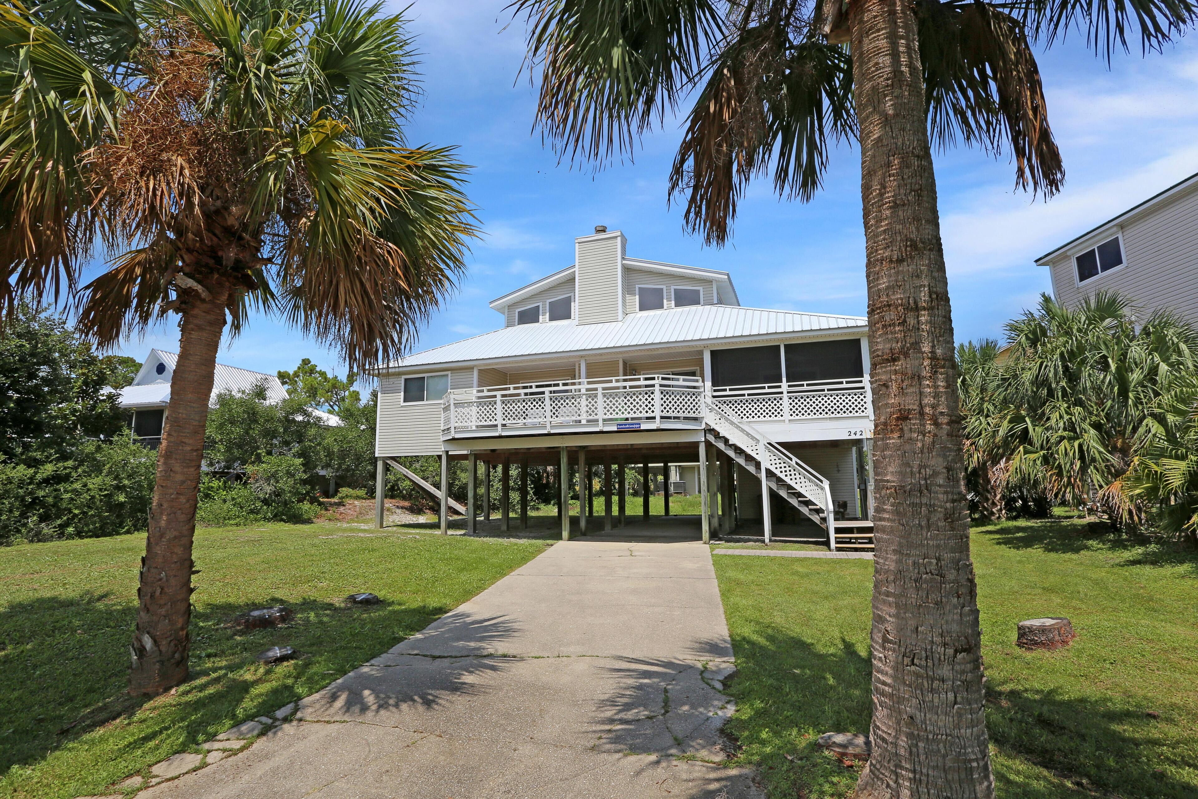 A two-story house with a covered porch and a staircase leading to the upper level.
