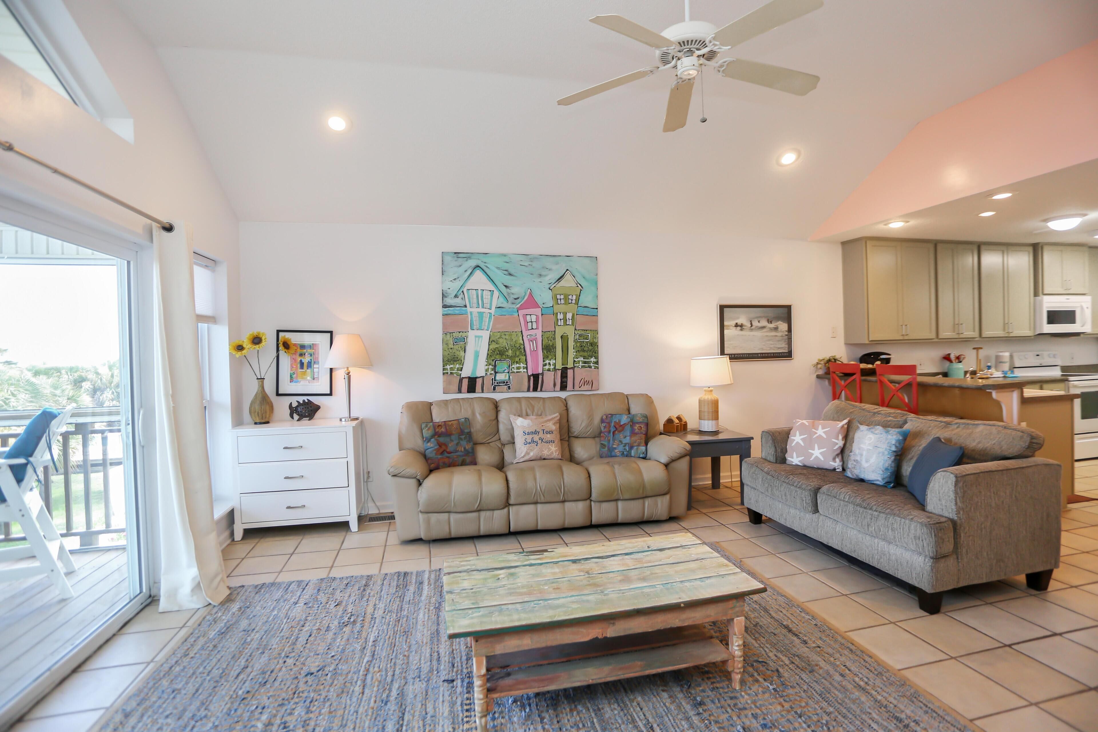 A spacious living room with two sofas, a coffee table, and a painting on the wall.