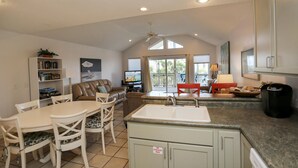 A spacious kitchen with a dining area, a living room, and a view of the outdoors. - 2-The-Beach (Port St. Joe)