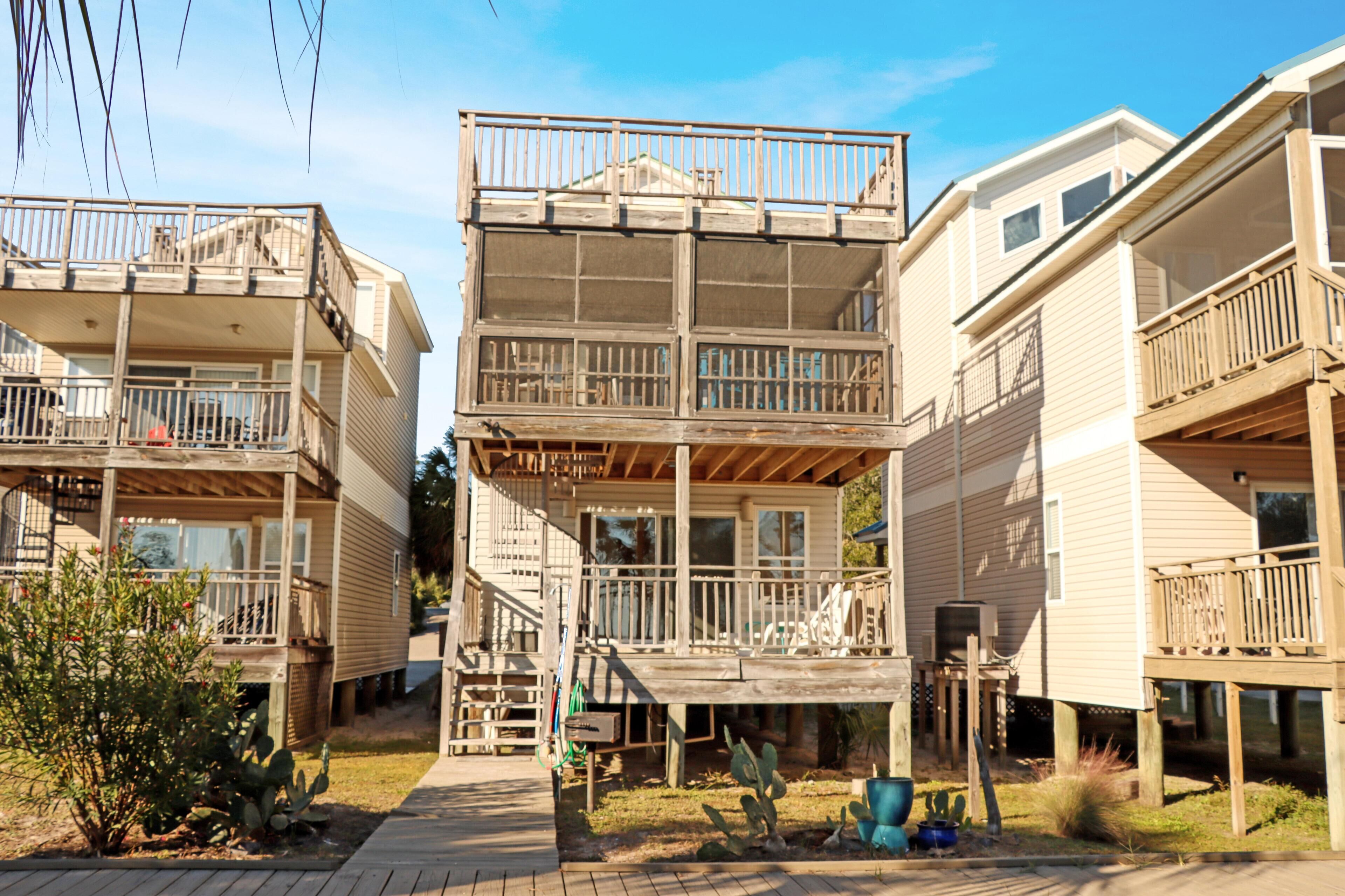 Un edificio residencial de varios pisos con balcones y una terraza de madera.
