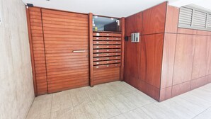 A modern room with a wooden wardrobe, a built-in wardrobe with multiple compartments, and a tiled floor. - Island Time Holiday Apartment (Larnaca)