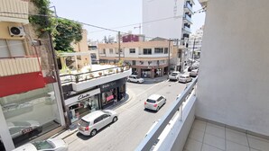 A street view with a building labeled "Clarks" and a "PARFOIC" store. - Island Time Holiday Apartment (Larnaca)