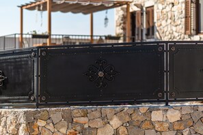 Un muro de piedra con una reja metálica adornada con detalles de metal.
