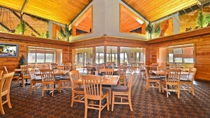 A spacious indoor dining area with wooden tables and chairs, large windows, and a high ceiling with exposed beams. - Quality Inn & Suites Black River Falls I-94 (Black River Falls)