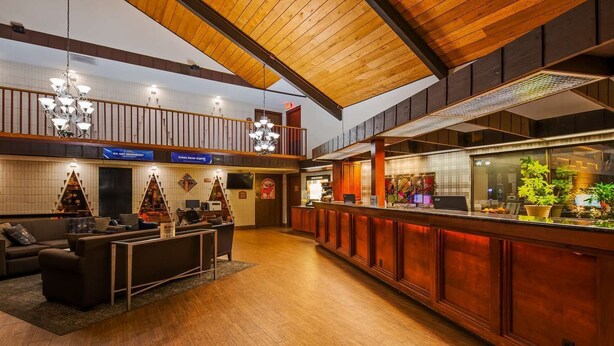 A spacious lobby with a wooden ceiling, a reception desk, and a seating area with a sofa and coffee table. - Quality Inn & Suites Black River Falls I-94 (Black River Falls)