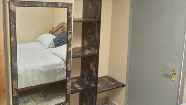 A compact room with a bunk bed, a small desk, and a wardrobe.